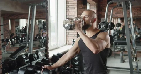 A man drinks water in the gym Stock Footage 219256337