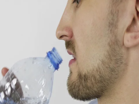 Man drinks water from a plastic bottle. 4K Stock Footage 75517895