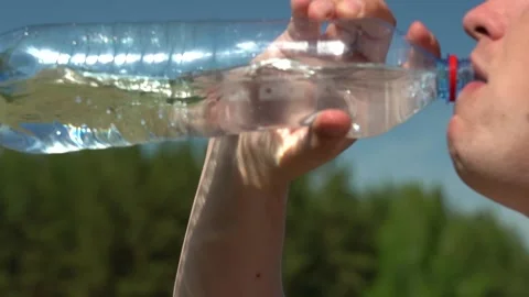 Man drinks water from a plastic bottle. Stockbeeldmateriaal 161816226