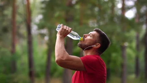 Man drinks water from a sports bottle while training Stock Footage 146836768