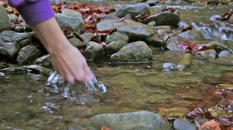 Man drinks water from a stream Stock Footage 45430326