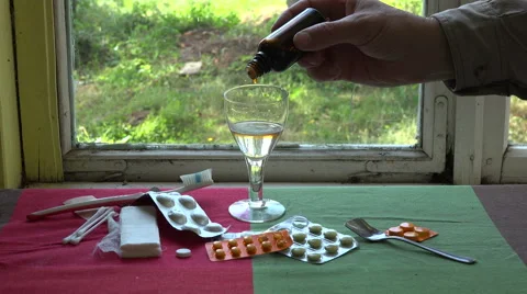 Man dripping medication drops in water, 4K Stock Footage 59081400