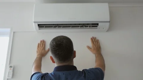 A man dripping with sweat cools under a stream of cold air standing next to a 스톡 동영상 109355138