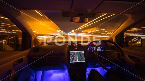 The man drive car in the city road. Left side traffic. Evening night time Stock Photos