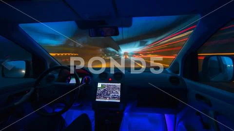 The man drive a car in the evening city. Inside view. Wide angle Stock Photos