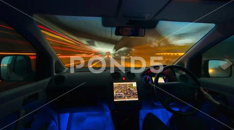 The man drive a car on the evening highway. Inside view. Left side traffic Stock Photos