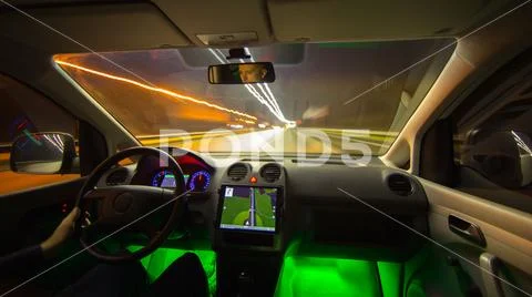 The man drive a car with gps in the night city. Wide angle. Inside view Stock Photos