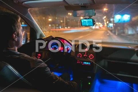 The man drive a car in the night city. Inside view Stock Photos
