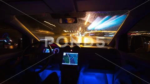 The man drive with a gps on the night road. Inside view. Wide angle Stock Photos