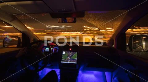 The man drive with a gps on the night road. Inside view. Wide angle Stock Photos