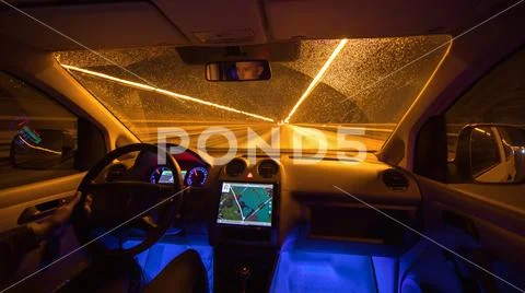 The man drive with a gps on the road. Evening night time. Inside view Stock Photos