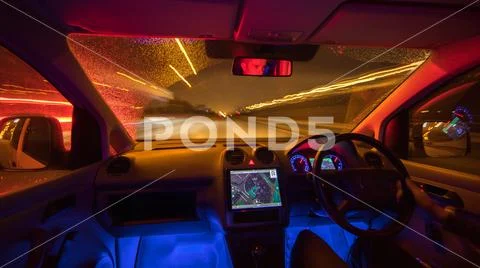 The man drive with a map on a rainy road. Evening night time. Left side traff Stock Photos
