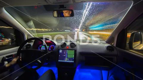 The man drive with a navigation on the night highway. Inside view Stock Photos