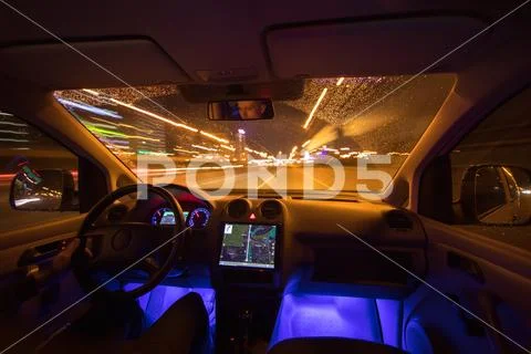 The man drive with navigation in the rain city. Inside view. Evening night ti Stock Photos