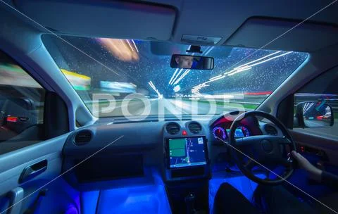 The man drive with a navigation on the rain highway. Evening night time Stock Photos