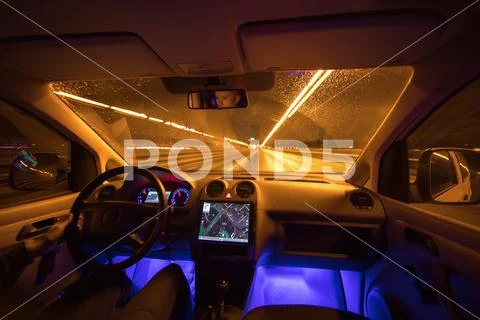 The man drive on the rain highway. Evening night time. Inside view Stock Photos
