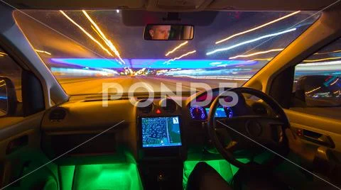 The man drive in the road with a navigation. Evening night time. Inside view Stock Photos