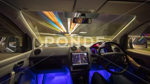 The man drive vehicle in the city road. Left side traffic. Evening night time Stock Photos