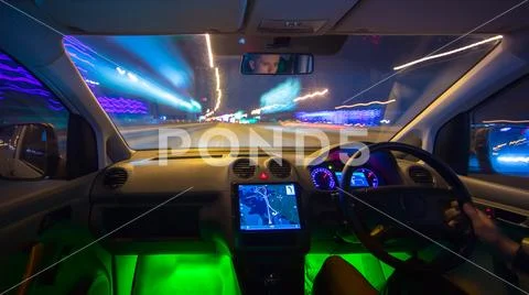 The man drive a vehicle on the night road. Inside view. Left side traffic Stock Photos