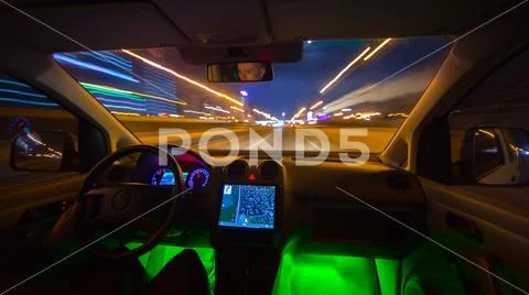 The man drive a vehicle on the night road. Inside view Stock Photos
