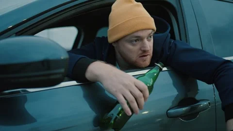 Man driver in cap with beer bottle in hand looking Stock Footage 260074721