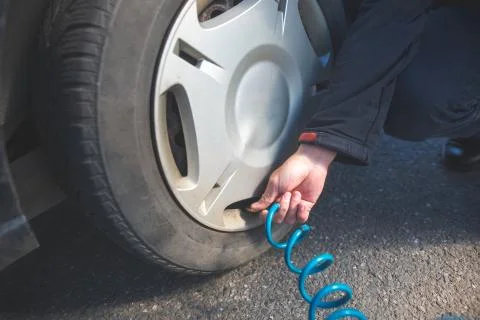 Man driver checking air pressure and filling air in the tires of his modern car Stock Photos