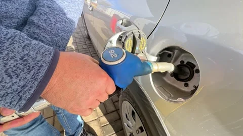 Man driver hand refilling and pumping gasoline oil the car with fuel  Stock Footage 294266112