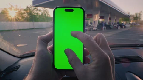 Man driver inside car zoom out display smart phone with green screen. Guy parked 動画素材 319041638