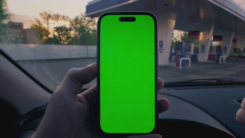 Man driver inside car zoom in display smart phone with green screen. Guy parked Stock Footage 319927598