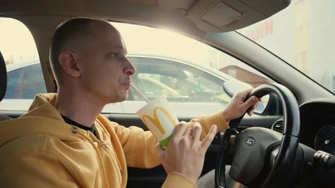 Man driver sit in a car hold drink a cup of coca cola from mcdrive - sweet carbo Stock Footage 142632467