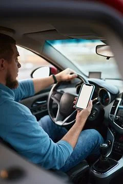 Man driver using mobile phone screen blank mockup on the road while driving a Stock Photos