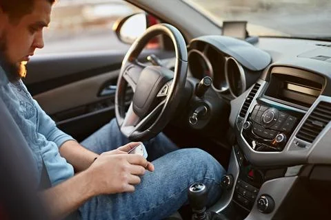 Man driver using mobile phone while sitting at the wheel of a car Stock Photos