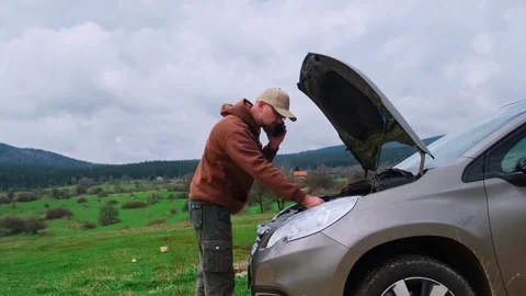 Man driver using smartphone calling auto service assistance. Road trip trouble. Stock Footage 249979364