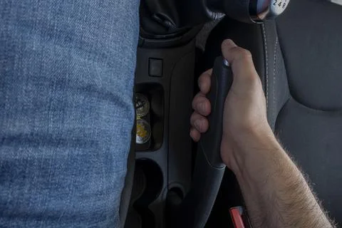 Man driver's hand pulling the handbrake in the car. Stock Photos