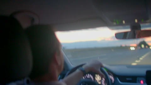 A man drives alone down a highway, reflecting on life at sunset Stock Footage 314346867