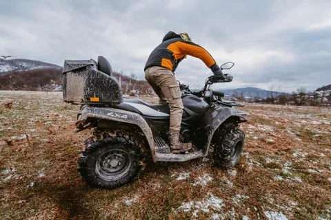 A man drives an ATV in the mud. Drift driving an ATV quad in mud and snow Stock Photos