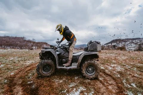 A man drives an ATV in the mud. Drift driving an ATV quad in mud and snow Stock Photos