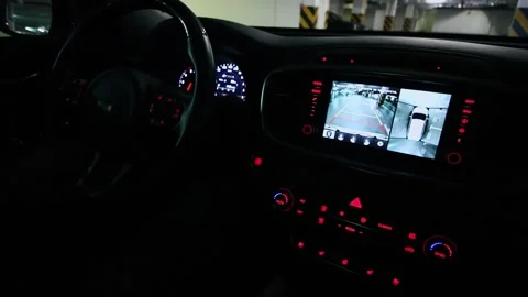 Man drives car backward by underground parking and rear view shown at display of Video stock 276370576