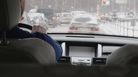 Man drives car on road full of automobiles and covered with snow Stock Footage 101154784