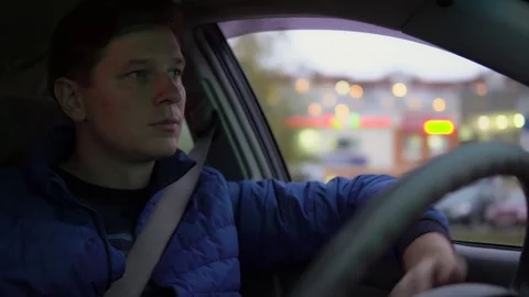 A man drives a car through the evening city. Stock Footage 81234906