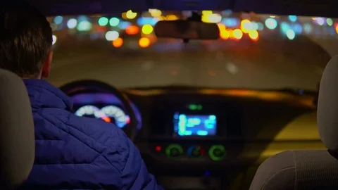 A man drives a car through the night city. Stock Footage 82536458