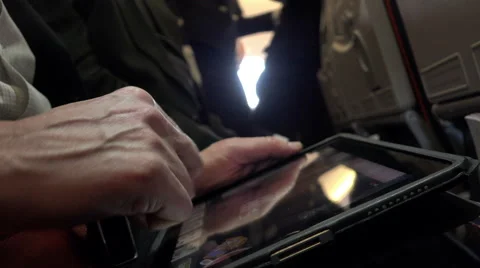 Man drives a finger on the screen of the tablet wearing seat belts in the Stock Footage 66192728