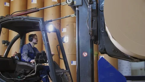Man drives forklift loader lifting up paper roll in workshop 스톡 동영상 113729767