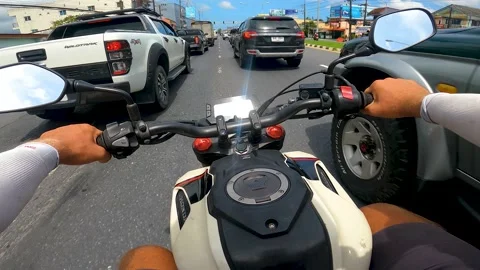 A man drives a motorcycle at high speed between cars Vídeo Stock 171910089