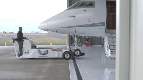Man Drives Pushback Tractor Attached to Jet 스톡 동영상 208714370