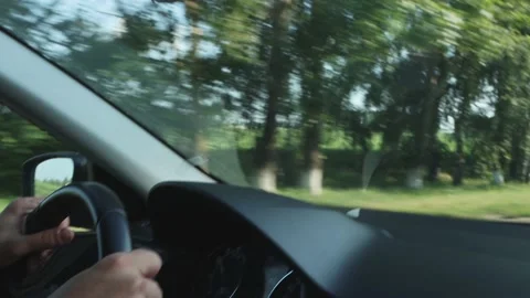 A man drives a vehicle, interior view. Road trip, flashing trees and landscape Stock Footage 157526259