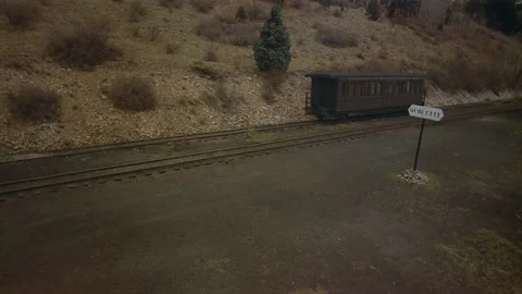 Man driving alongside a train in the Rocky Mountains, Colorado, USA. Stock Footage 163175940
