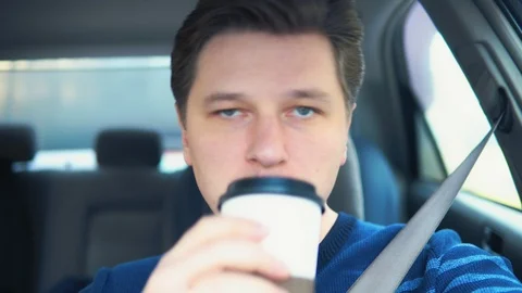 The man is driving and drinking coffee Stock Footage 87663828