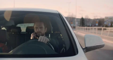 Man driving and talking on the phone in Warsaw on a sunny day Stock Footage 170428847