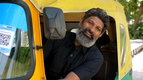 A man driving an auto rickshaw - posing for the camera, sitting on driver sea... Stock Footage 258649308